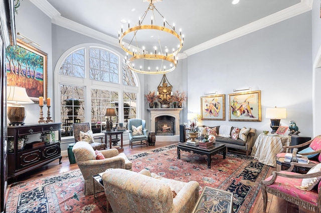 living room featuring a chandelier, wood finished floors, crown molding, recessed lighting, and a towering ceiling