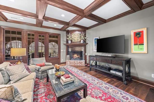 living area featuring wood finished floors, baseboards, coffered ceiling, a fireplace, and beam ceiling