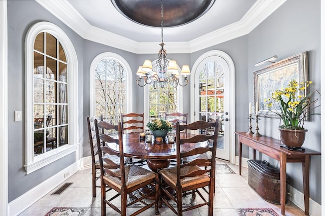 dining space featuring a chandelier, ornamental molding, healthy amount of natural light, light tile patterned flooring, and baseboards