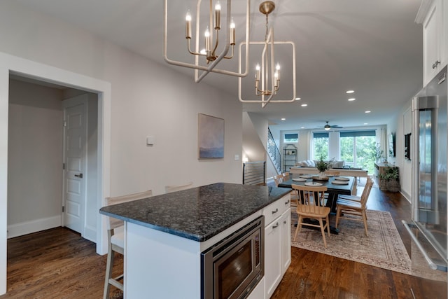 kitchen with built in appliances, a chandelier, dark wood-style flooring, white cabinets, and recessed lighting