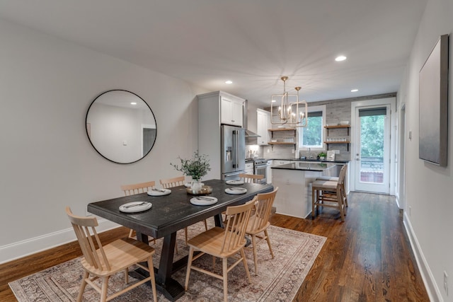 dining space with a chandelier, dark wood-style flooring, recessed lighting, and baseboards