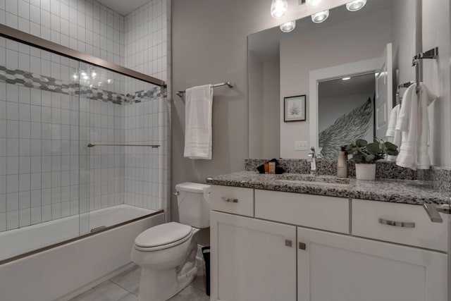 bathroom with toilet, vanity, bath / shower combo with glass door, and tile patterned floors