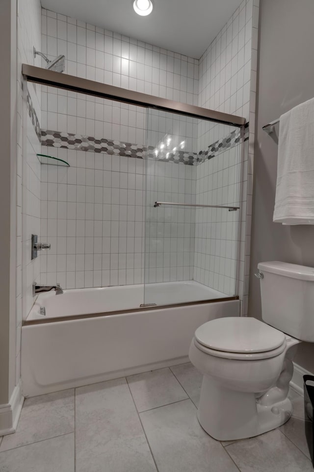 full bath with toilet, bath / shower combo with glass door, and tile patterned floors