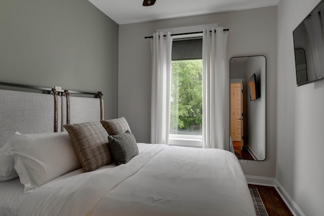 bedroom with dark wood finished floors and baseboards
