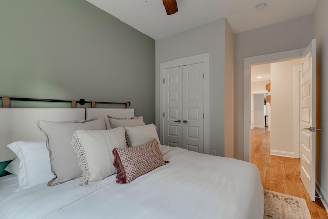 bedroom with a closet, wood finished floors, and a ceiling fan