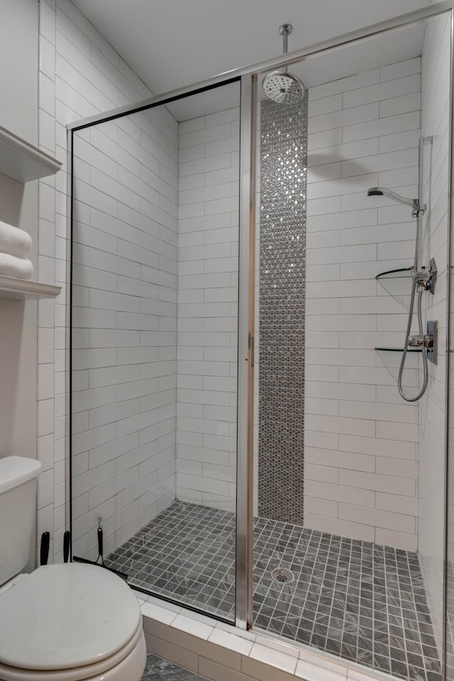 bathroom featuring toilet and a shower stall
