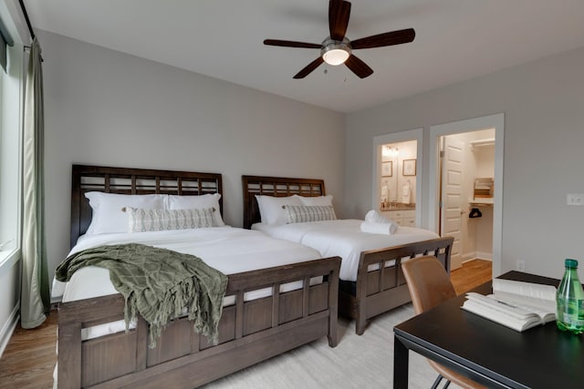 bedroom with light wood-style floors, ensuite bath, a ceiling fan, and baseboards