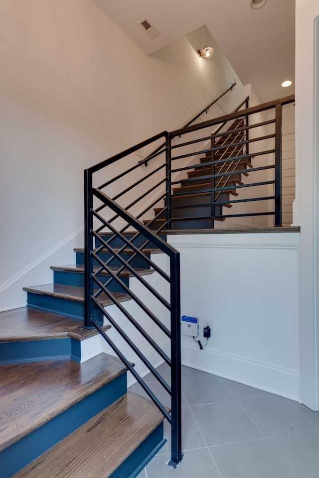 stairs featuring tile patterned flooring and recessed lighting