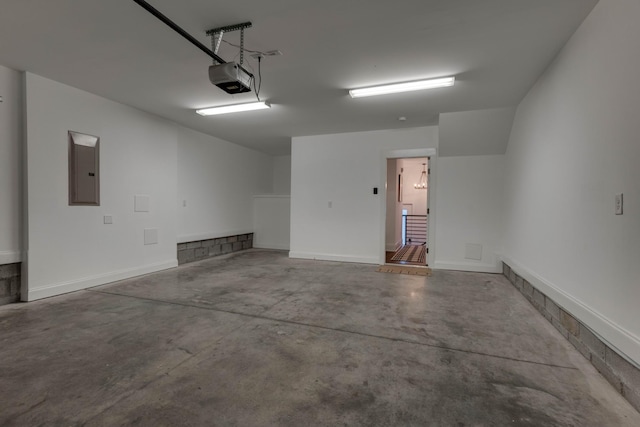 garage with electric panel, a garage door opener, and baseboards