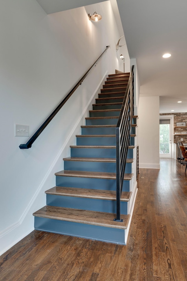 staircase featuring wood finished floors, recessed lighting, and baseboards