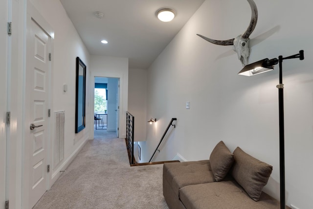 hallway featuring an upstairs landing, light carpet, baseboards, and recessed lighting