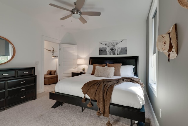 bedroom with light colored carpet, ceiling fan, and baseboards
