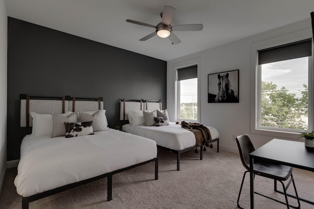 carpeted bedroom with multiple windows, a ceiling fan, and baseboards