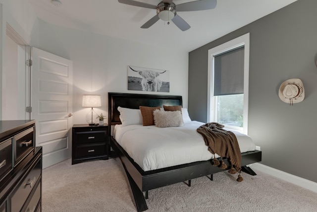 bedroom featuring light colored carpet, ceiling fan, and baseboards