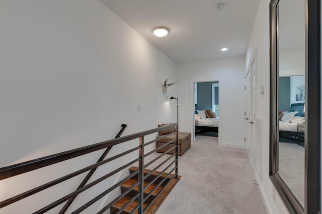 corridor with an upstairs landing, light carpet, and recessed lighting