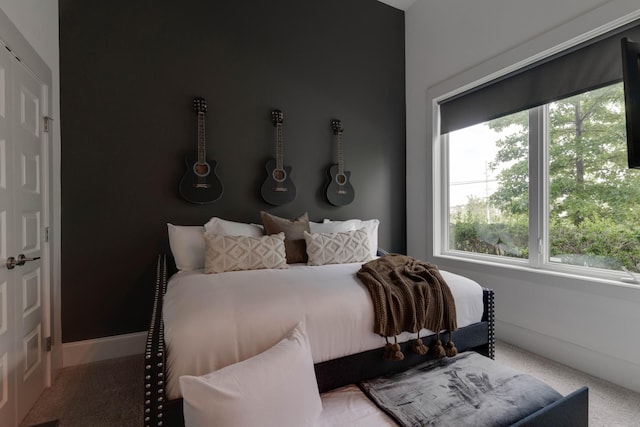 bedroom featuring multiple windows, carpet, and baseboards