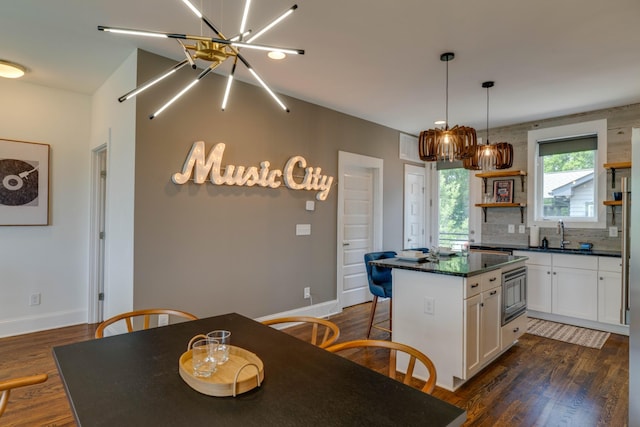 kitchen featuring stainless steel microwave, open shelves, dark countertops, white cabinets, and dark wood-style flooring