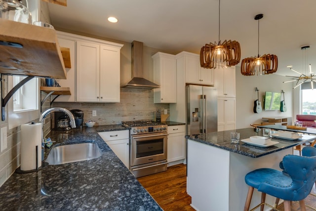 kitchen featuring appliances with stainless steel finishes, wall chimney exhaust hood, a sink, white cabinetry, and dark wood-style floors