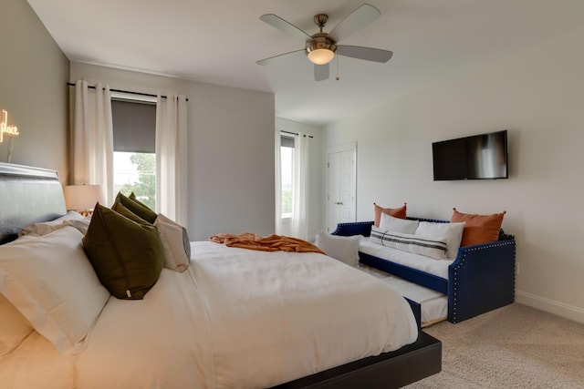 carpeted bedroom with ceiling fan and baseboards