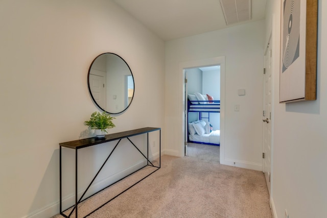 hallway featuring light carpet and baseboards