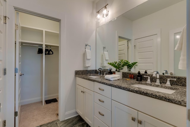 full bathroom with double vanity and baseboards