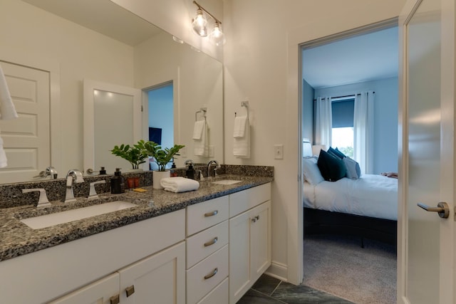ensuite bathroom with double vanity and baseboards