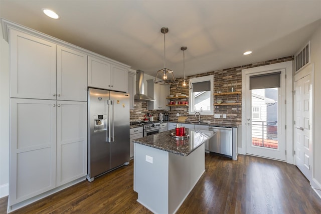 kitchen featuring premium appliances, open shelves, wall chimney exhaust hood, a sink, and dark wood-style floors