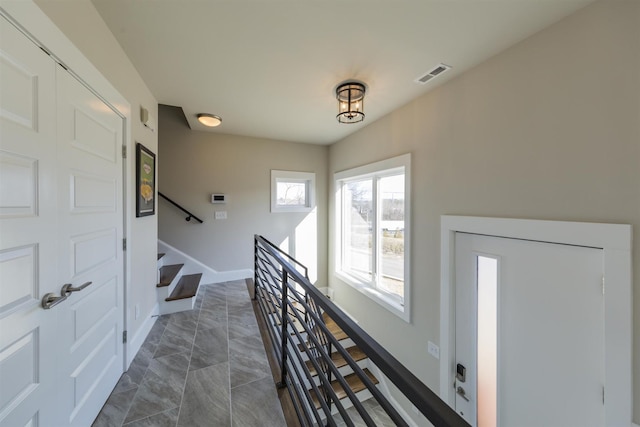 entrance foyer featuring stairway and baseboards