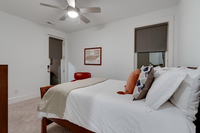 carpeted bedroom with ceiling fan and baseboards