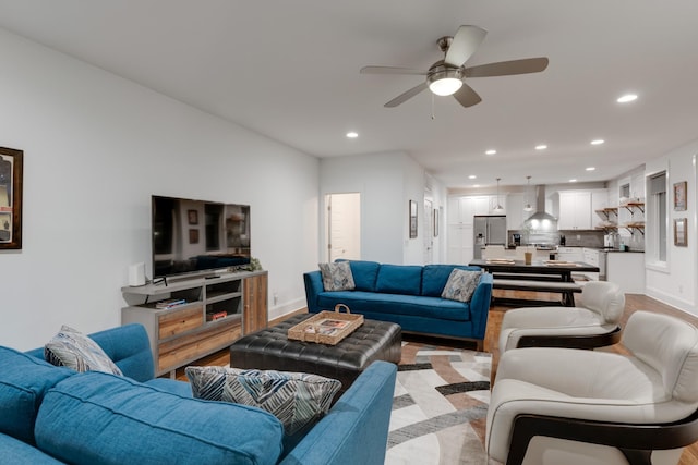 living area featuring recessed lighting, a ceiling fan, baseboards, and light wood finished floors