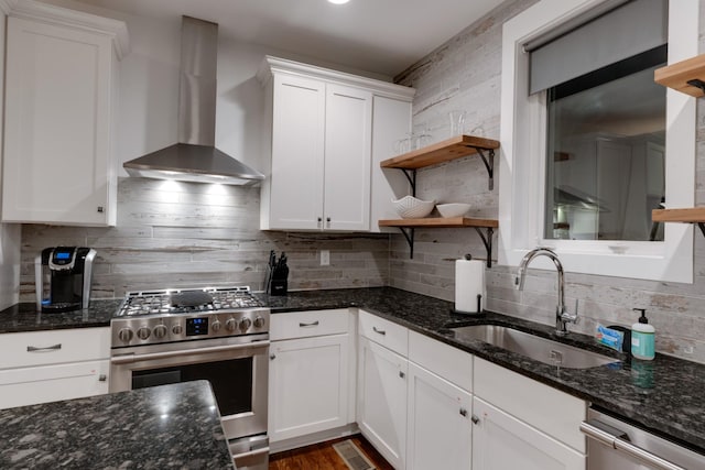 kitchen with appliances with stainless steel finishes, open shelves, a sink, wall chimney exhaust hood, and white cabinetry
