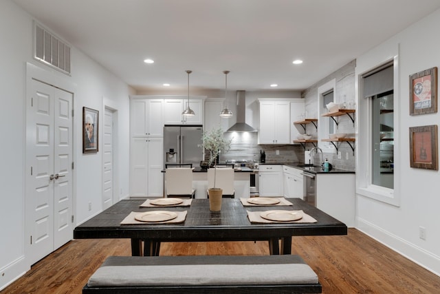 dining space with dark wood-type flooring, recessed lighting, and baseboards