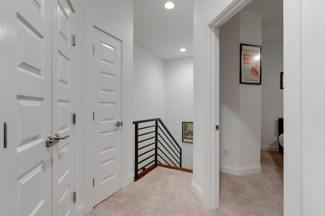 corridor featuring carpet, baseboards, an upstairs landing, and recessed lighting