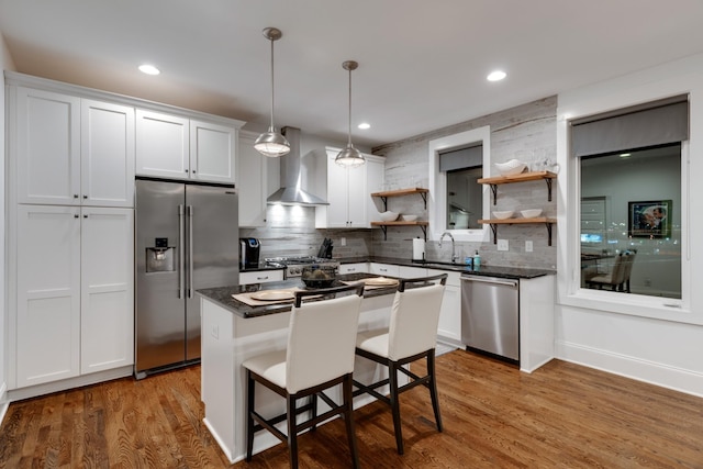 kitchen featuring stainless steel appliances, open shelves, wall chimney range hood, tasteful backsplash, and recessed lighting