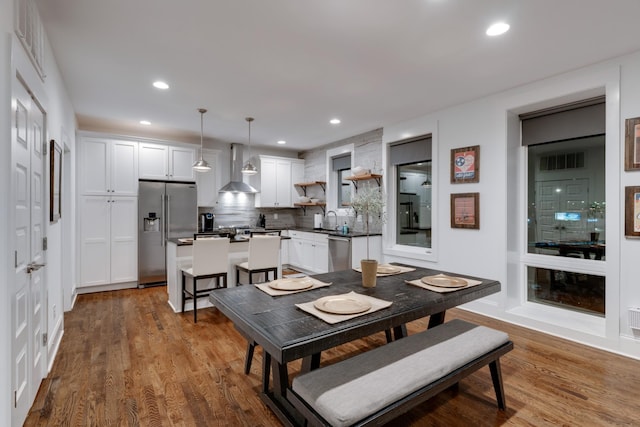 dining space with wood finished floors and recessed lighting