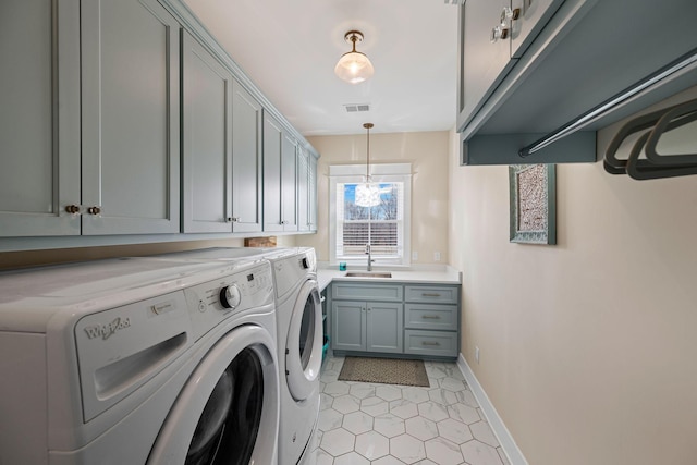 7480 Horn Tavern Rd, Fairview, TN 37062 - laundry area featuring washer and clothes dryer, cabinet space, baseboards, light tile patterned floors, and a chandelier