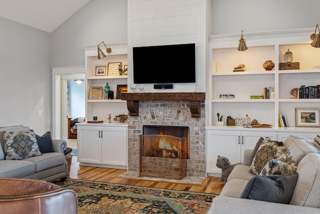 7480 Horn Tavern Rd, Fairview, TN 37062 - living room with light wood-style floors, vaulted ceiling, a fireplace, and built in features