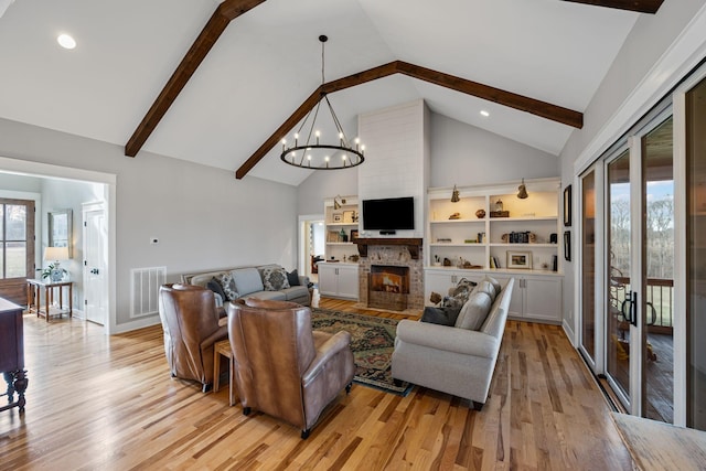 7480 Horn Tavern Rd, Fairview, TN 37062 - living room featuring high vaulted ceiling, light wood finished floors, a chandelier, beam ceiling, and a large fireplace
