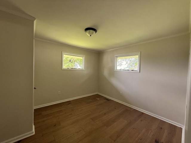 unfurnished room featuring healthy amount of natural light, baseboards, dark wood-style flooring, and crown molding
