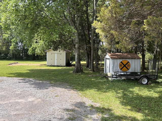 7324 Bermuda Dr, Christiana, TN 37037 - view of grassy yard with a storage unit, an outdoor structure, driveway, and view of wooded area