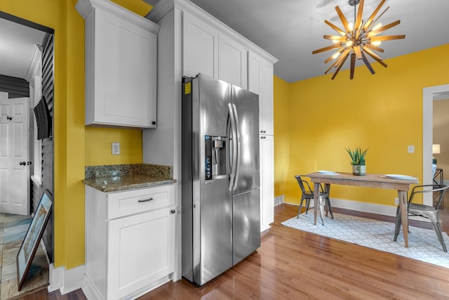 2642 Stuart St, Burns, TN 37029 - kitchen with stainless steel fridge with ice dispenser, baseboards, wood finished floors, and white cabinets