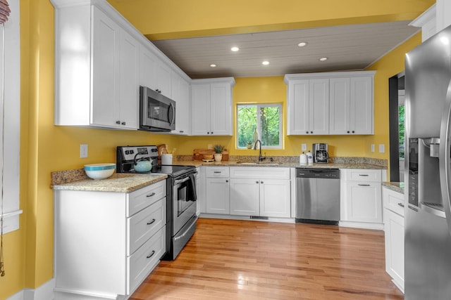 2642 Stuart St, Burns, TN 37029 - kitchen featuring stainless steel appliances, a sink, recessed lighting, light wood-type flooring, and white cabinets