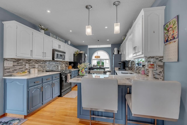 1383 Carters Creek Pike, Columbia, TN 38401 - kitchen featuring a sink, stainless steel appliances, a peninsula, blue cabinets, and white cabinetry