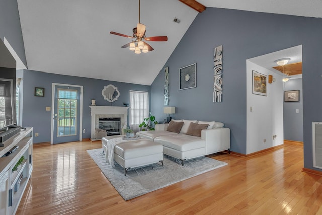 1383 Carters Creek Pike, Columbia, TN 38401 - living room featuring high vaulted ceiling, ceiling fan, a glass covered fireplace, beam ceiling, and light wood-style flooring