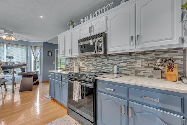 1383 Carters Creek Pike, Columbia, TN 38401 - kitchen with stainless steel appliances, blue cabinets, a textured ceiling, a ceiling fan, and white cabinetry