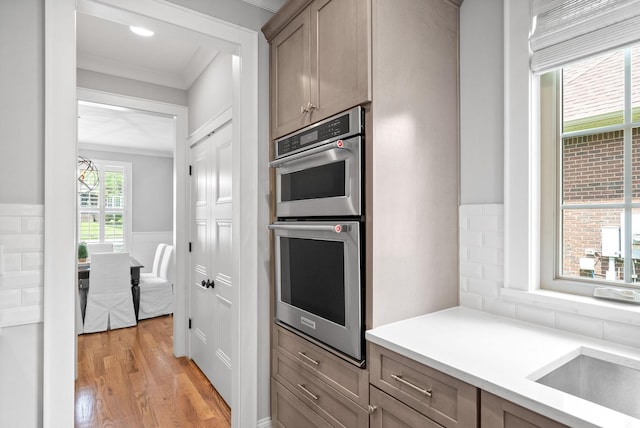 2477 Settlers Trce, Clarksville, TN 37043 - kitchen with double oven, light wood finished floors, ornamental molding, light countertops, and wainscoting