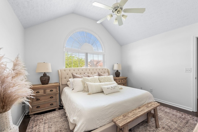 bedroom with wood finished floors, vaulted ceiling, a textured ceiling, baseboards, and a ceiling fan