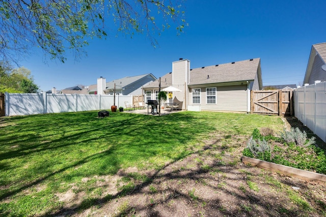 view of yard with a gate, a garden, and a patio