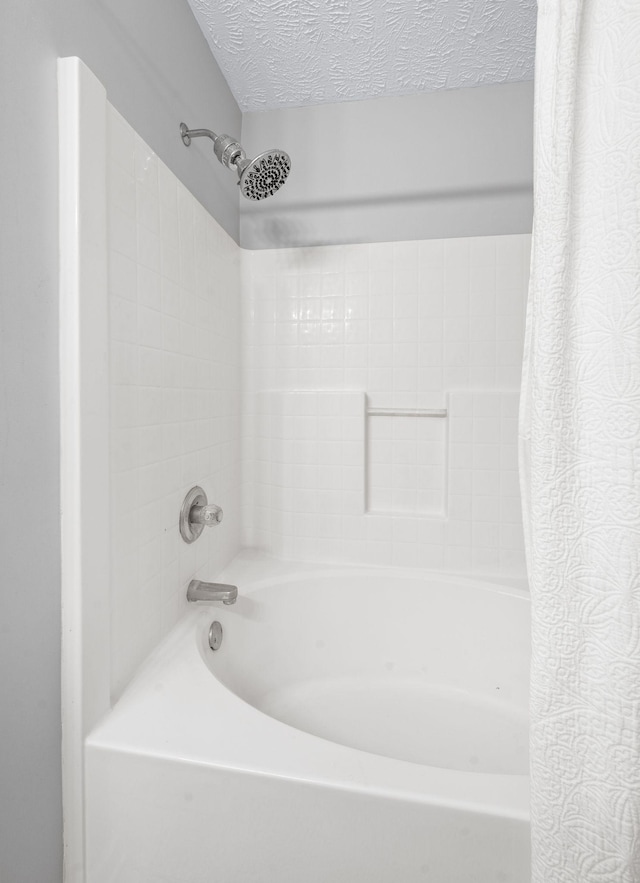full bathroom featuring a textured ceiling and shower / bath combo with shower curtain