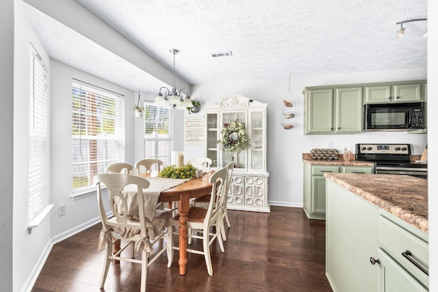 dining space featuring a textured ceiling, dark wood-type flooring, baseboards, and a chandelier